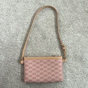 Pink Michael Kors logo patterned belt bag with a tan strap